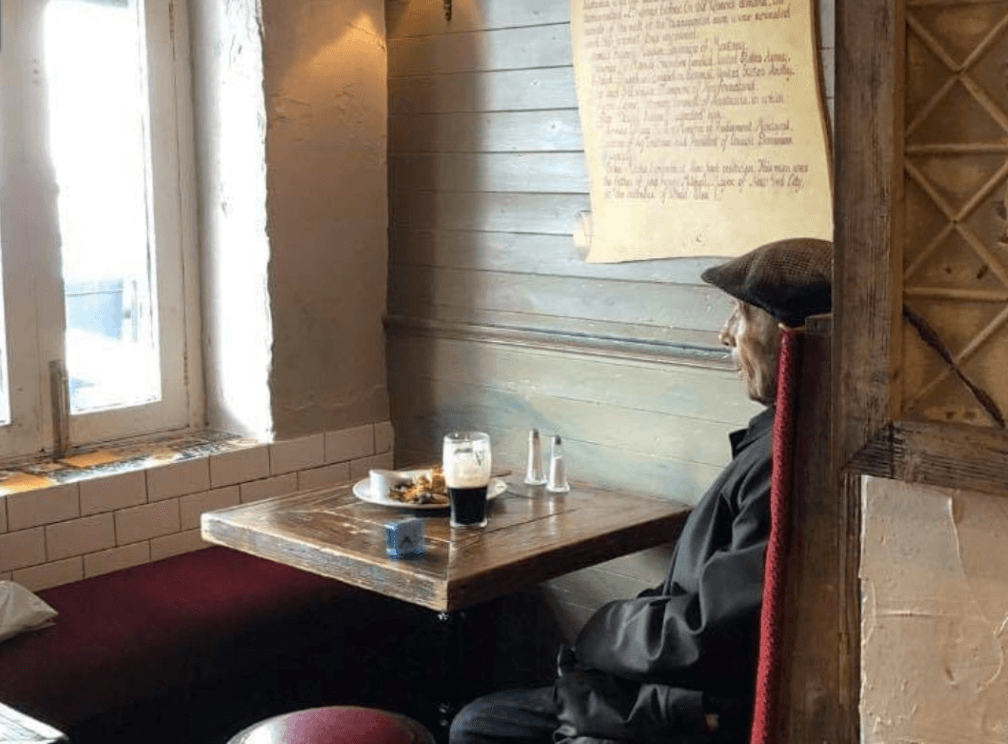 Public moved by heartbreaking photo of elderly man keeping time in pub with alarm clock